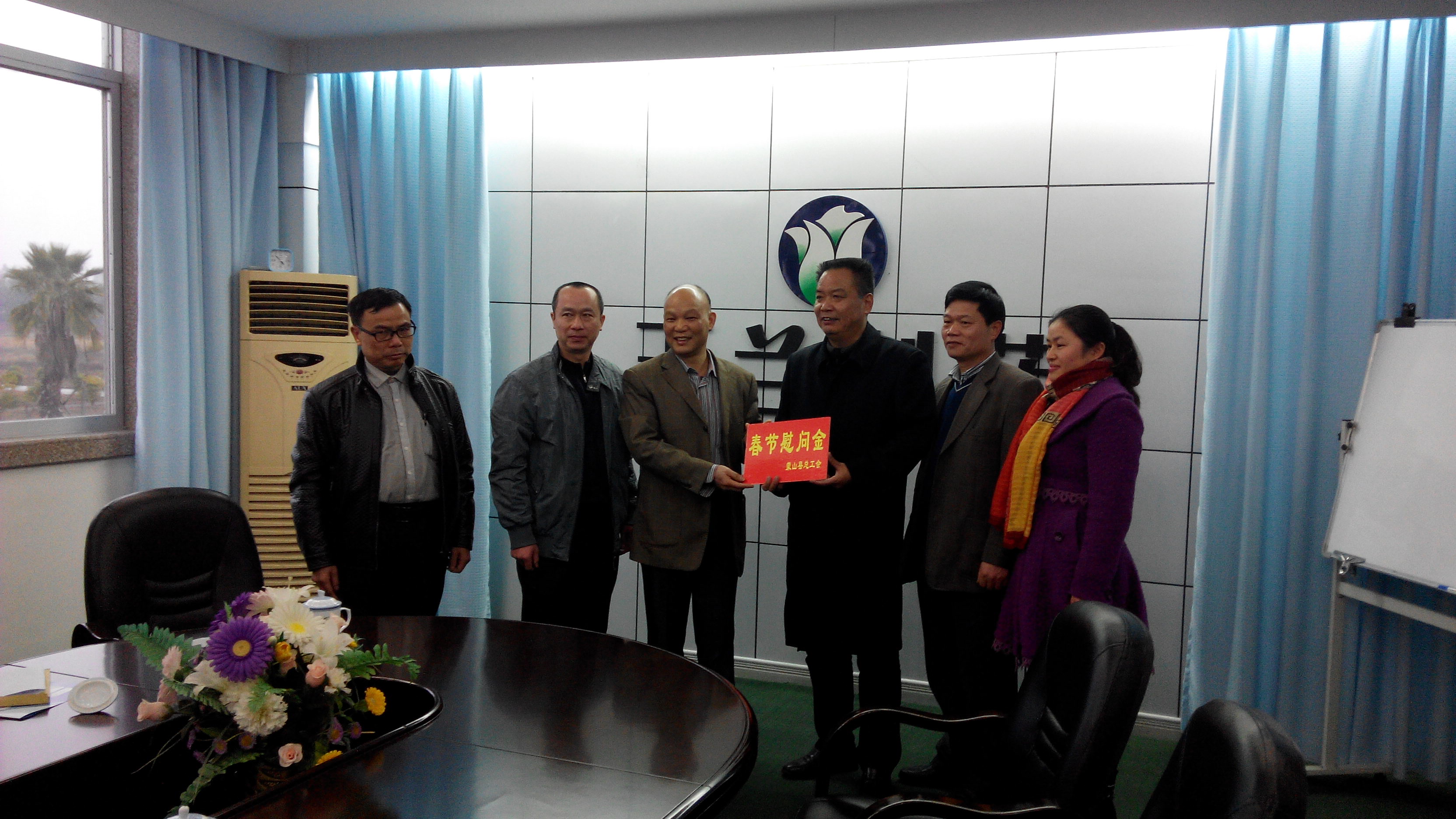 1月28日，梧州市總工會副主席謝海益帶隊到蒙山開展春節(jié)前慰問活動。圖為市總工會謝副主席給玉蘭制藥公司送上春節(jié)慰問金。--
