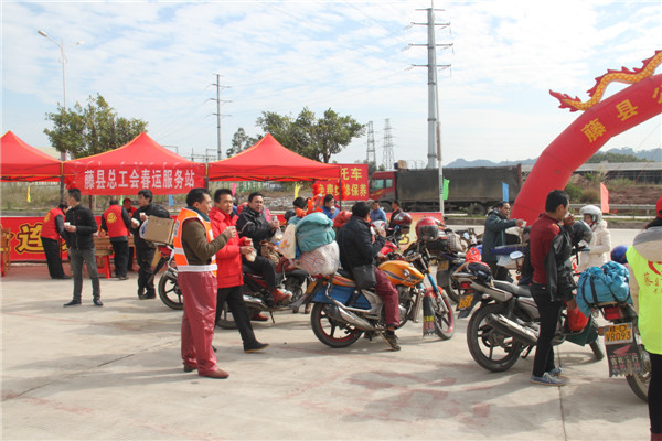 圖為藤縣總工會(huì)在省道304線藤縣陶瓷工業(yè)園區(qū)商業(yè)街小廣場(chǎng)設(shè)立藤縣總工會(huì)為農(nóng)民工平安返鄉(xiāng)“暖流行動(dòng)”服務(wù)站，積極為騎摩托車